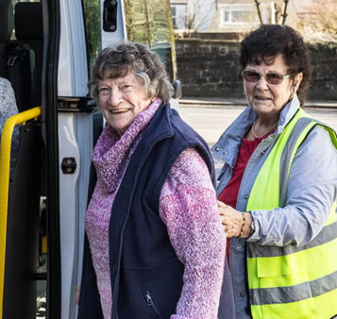 person helping a person onto a bus