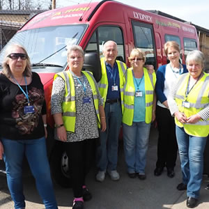 Group of employees stood by a vehicle